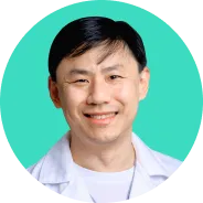 Doctor in white coat smiling with teal circular background