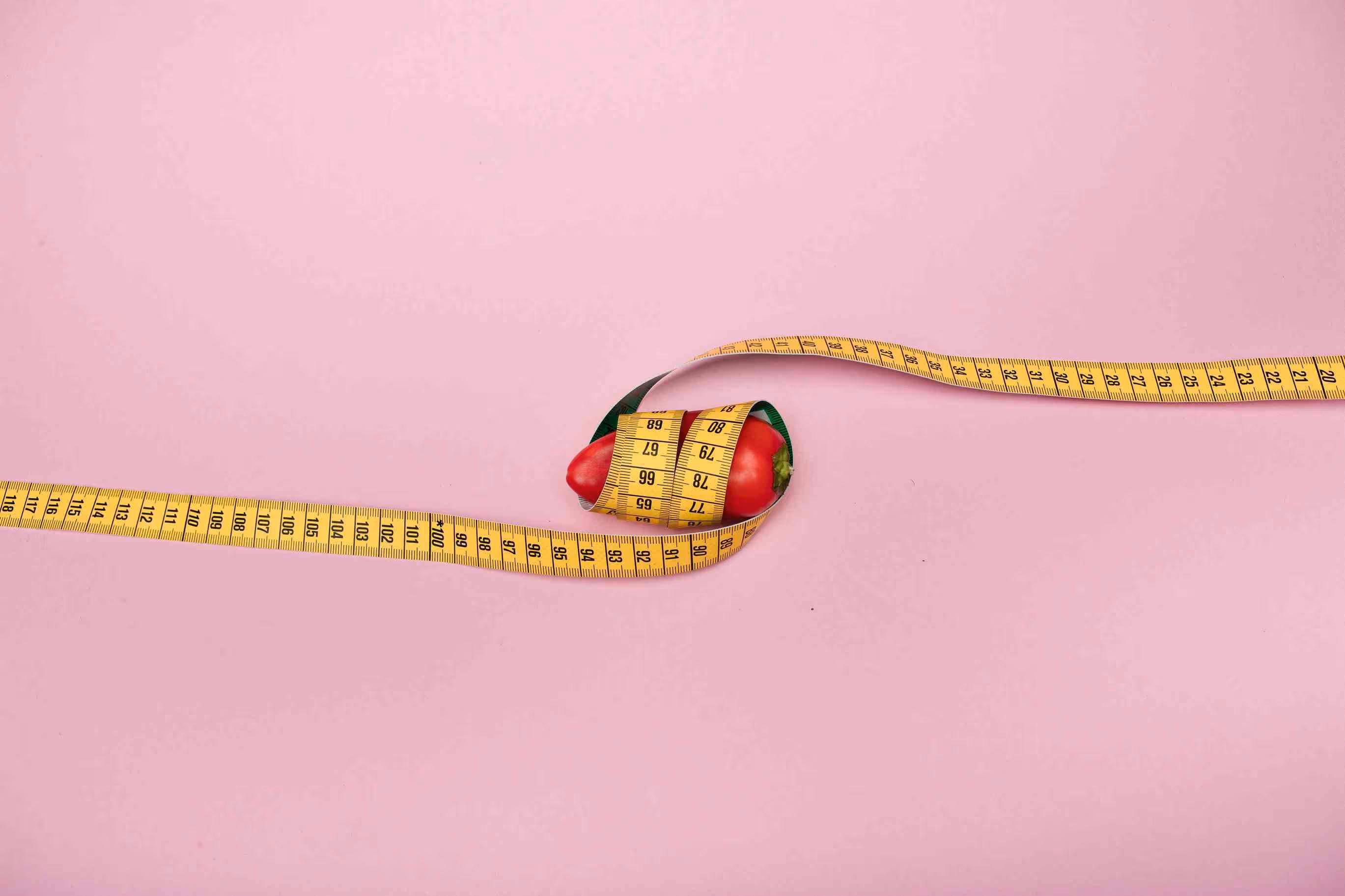 A small chili pepper wrapped in a measuring tape. 