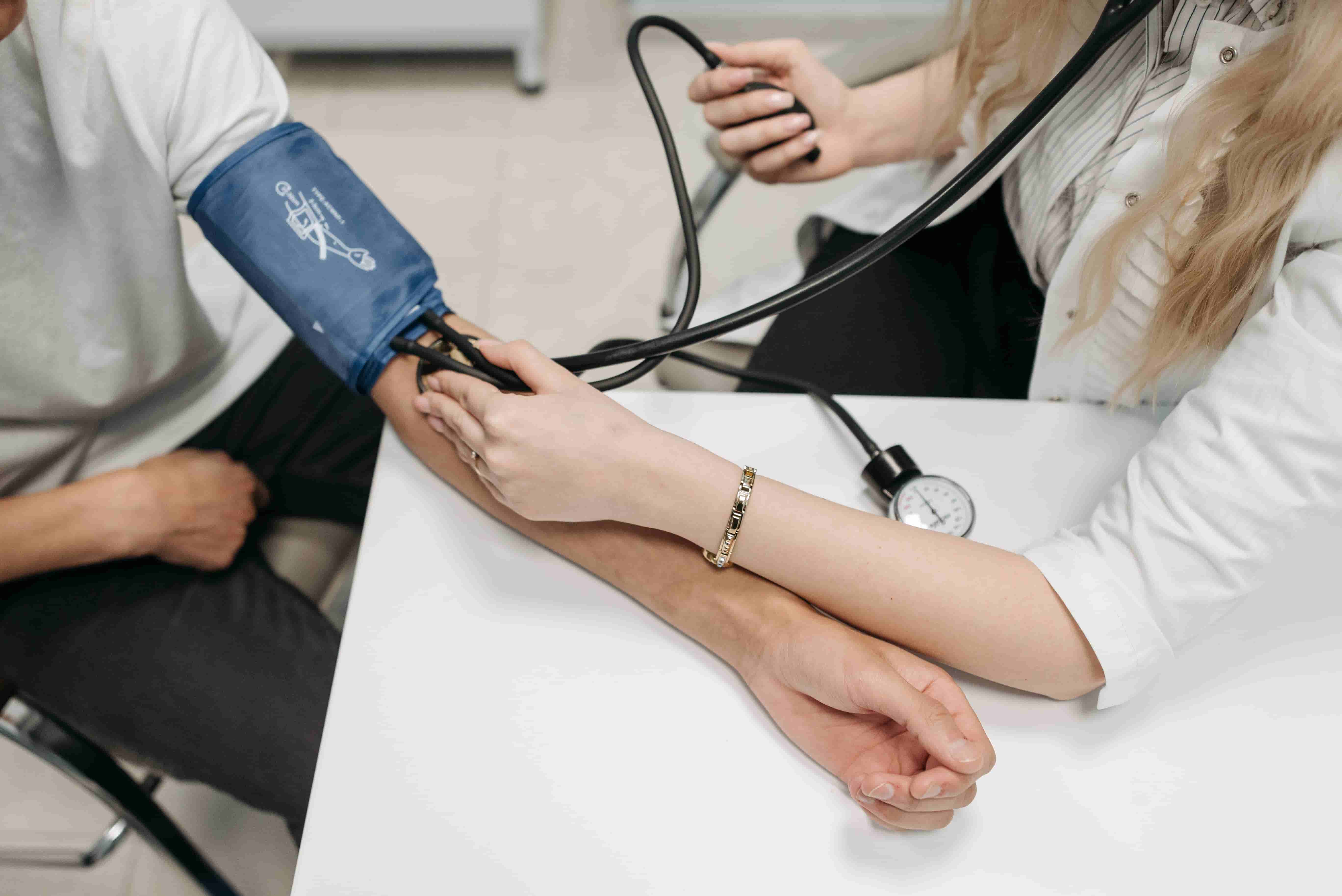 A doctor checking her patient's blood pressure with a sphygmomanometer