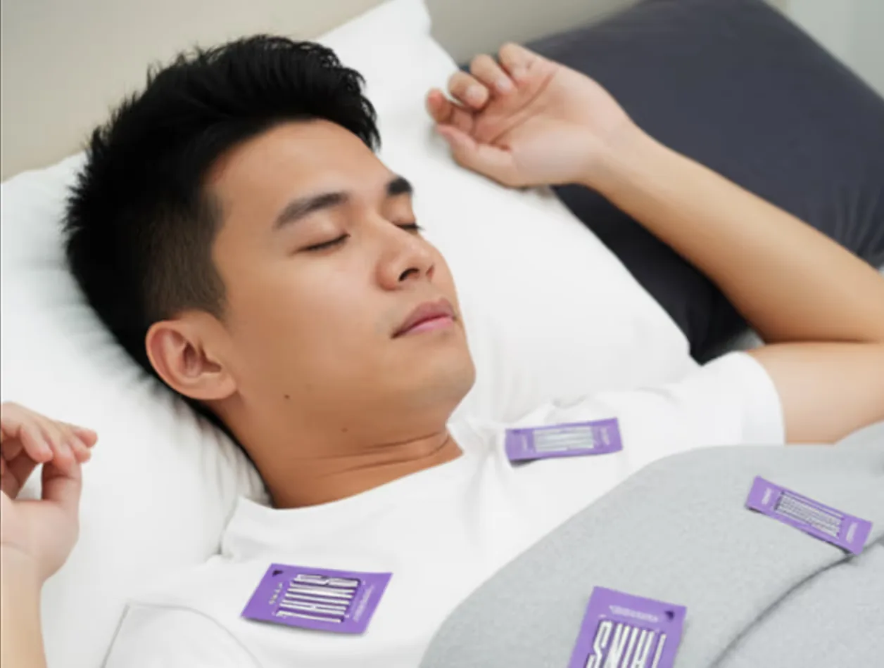 A man asleep in bed with Sleep Thins on the sheets