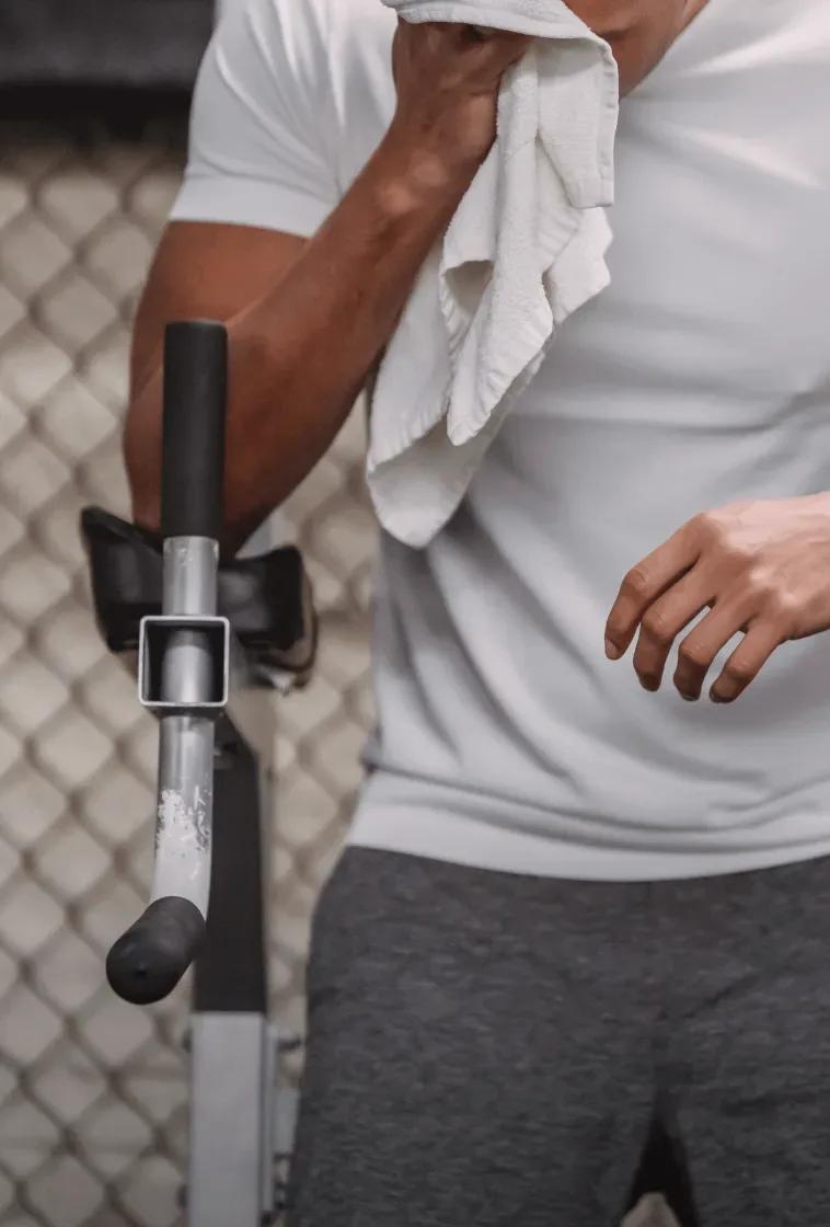 A man wiping his face with a towel after exercise