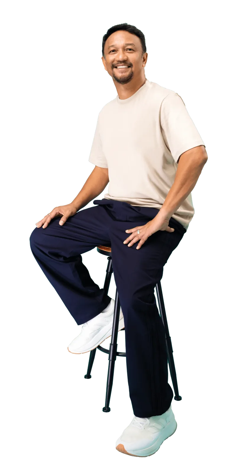 Fandi Ahmad sitting on a stool in a white shirt and jeans