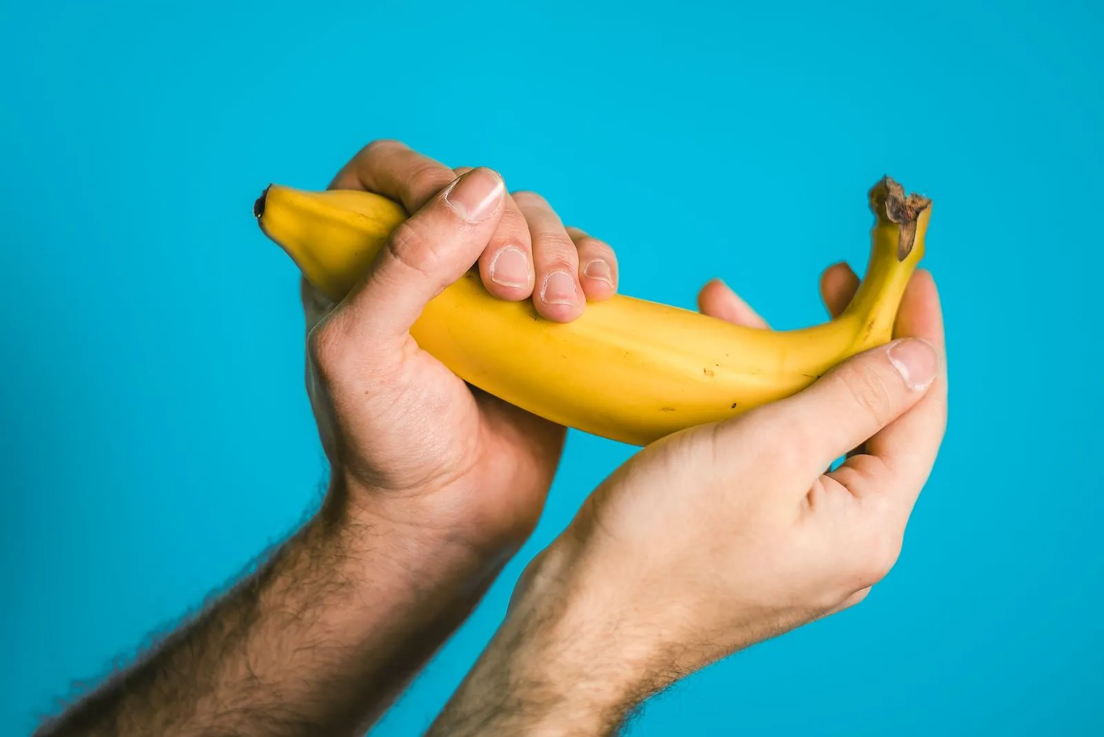 A person holding a banana with two hands