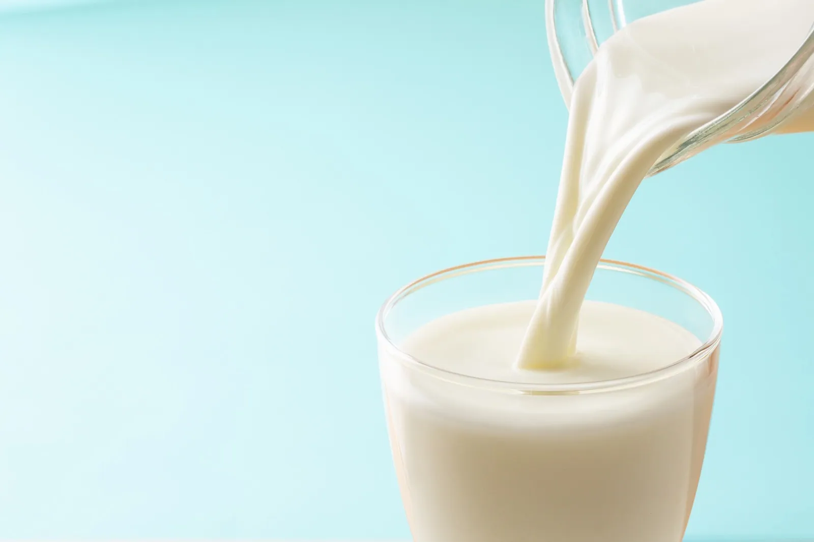 Pouring milk into a glass from a server
