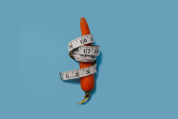 A carrot wrapped with white measuring tape