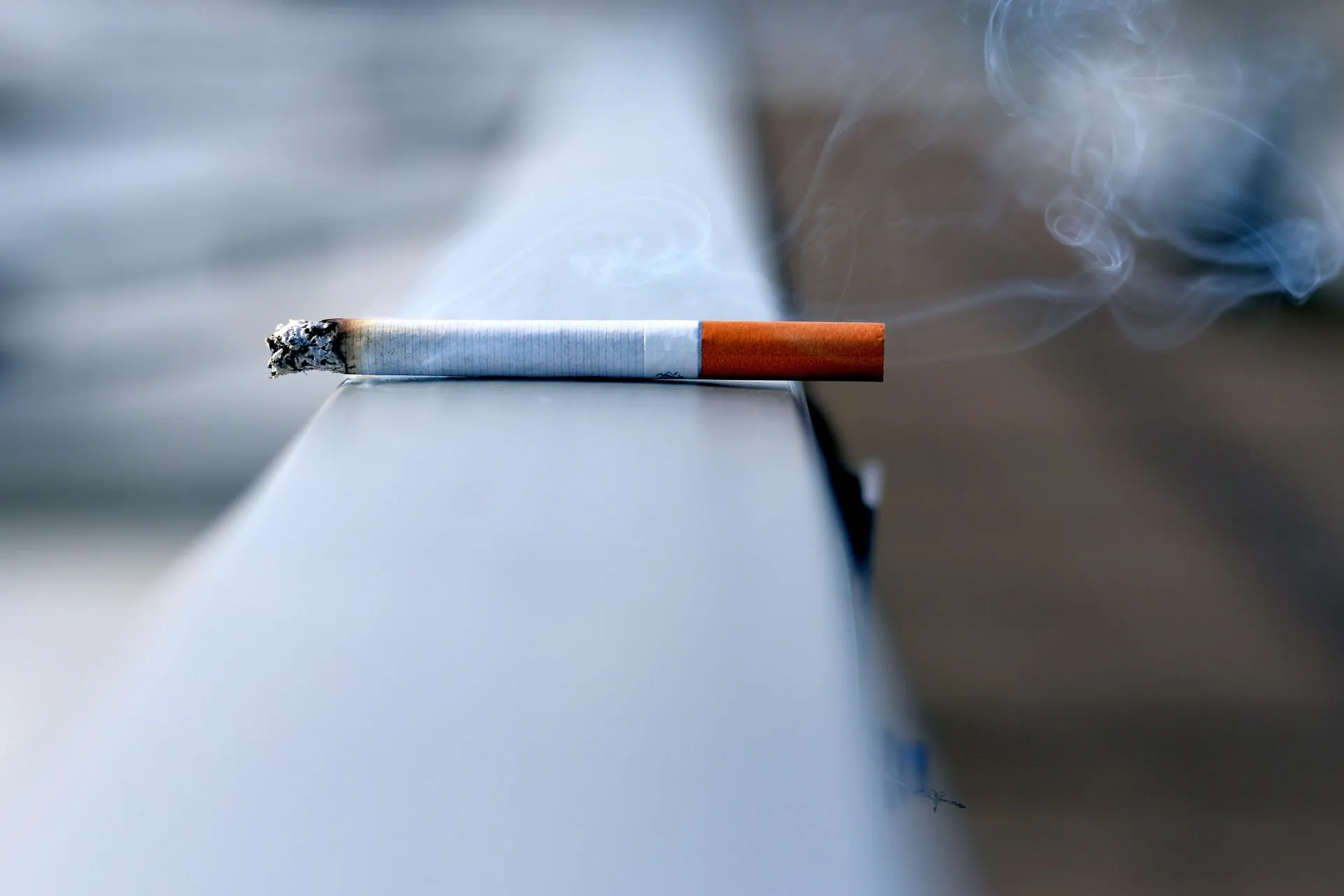 A used cigarette on top of a white ledge
