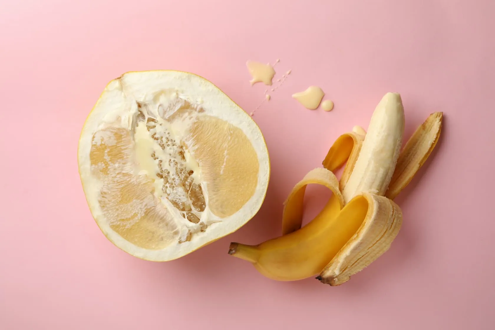 Half of a lemon next to a half-peeled banana