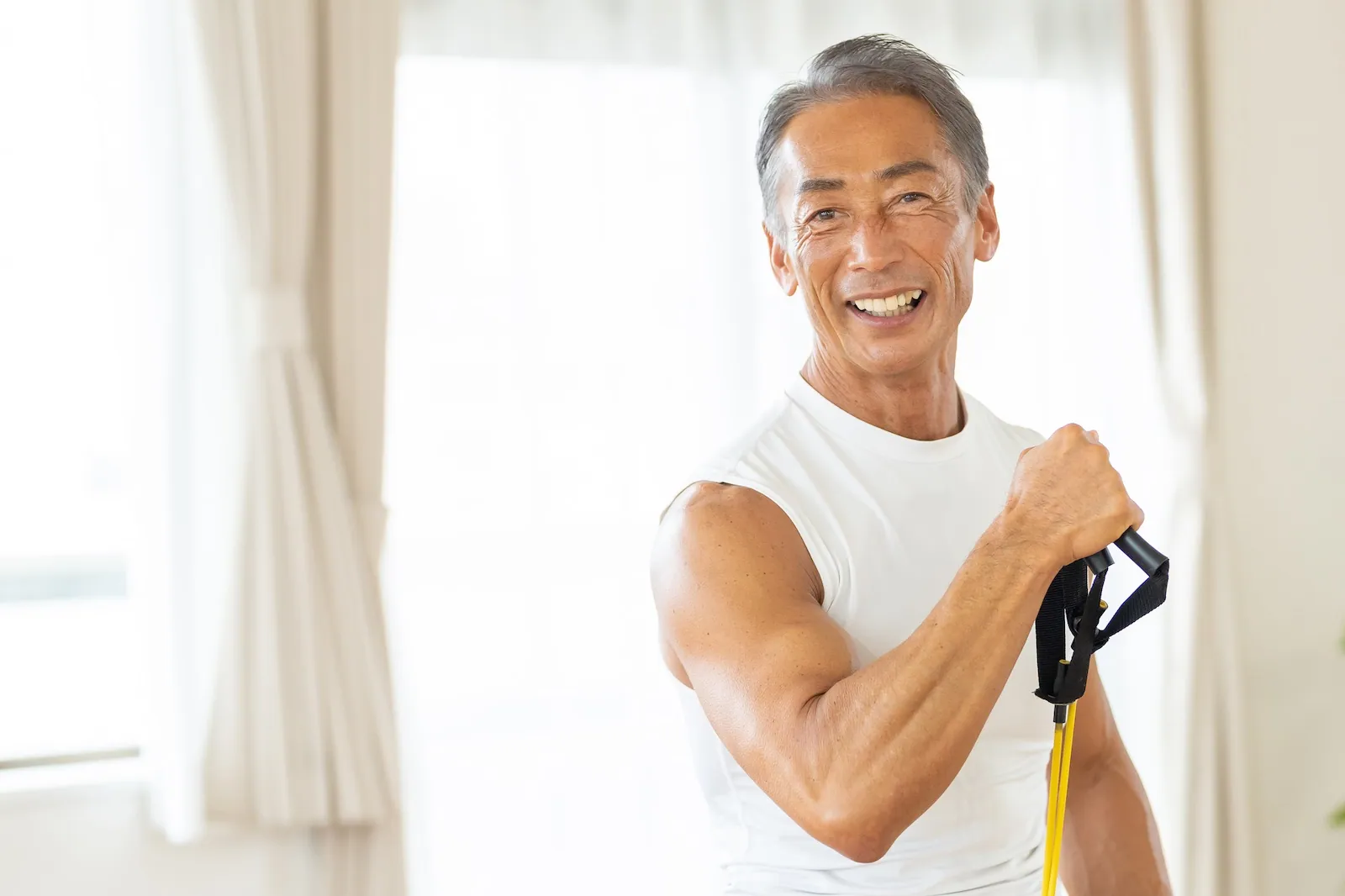 A strong middle-aged Asian man doing TRX exercises