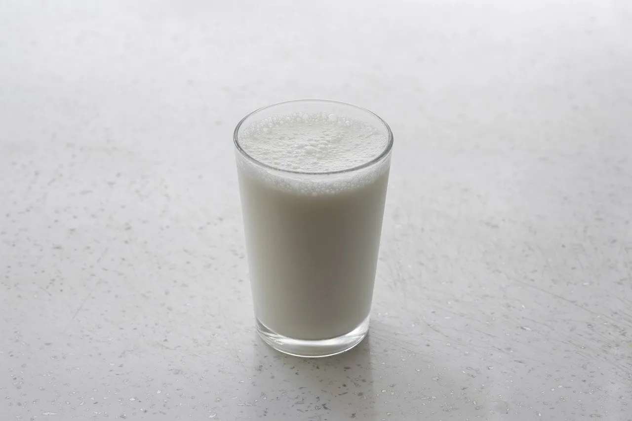 A full glass of milk on top of a white table