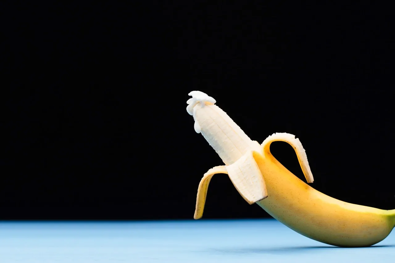 A peeled banana with suggestive white overflowing white tip. 