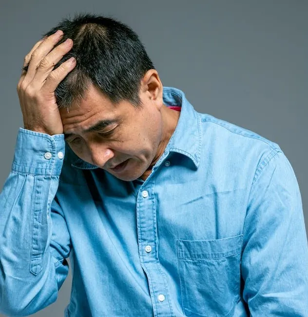 A middle-aged Asian male experiencing a headache