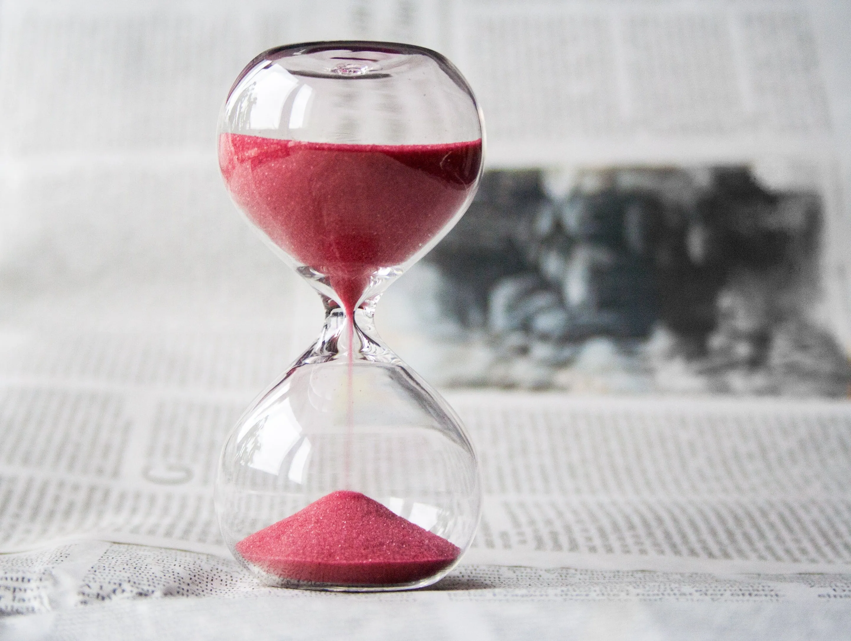 An hourglass filled with red sand